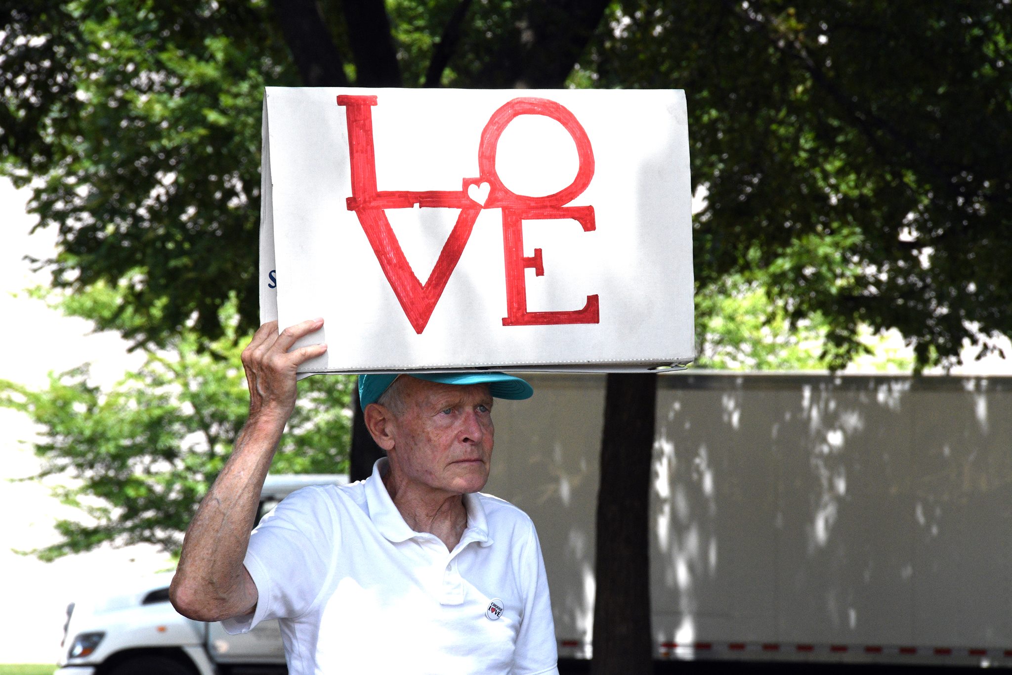 man holding a sign that says LOVE